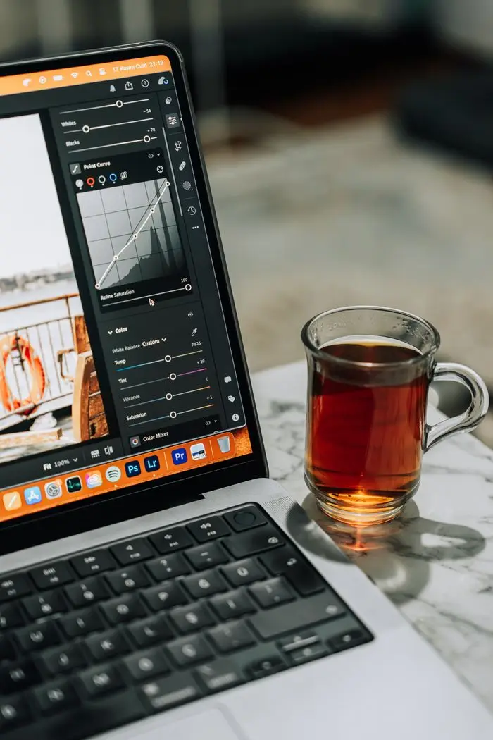 Modern workspace setup with laptop screen and a cup of tea on a marble surface. Ideal for tech lifestyle themes.